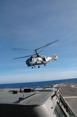 A Russian Federation Navy KA-27 Helix helicopter takes off from the flight pad aboard the USN Ticonderoga Class Guided Missile Cruiser (Aegis), USS COWPENS (CG 63) during a joint Russian Federation Navy-US Navy (USN) humanitarian assistance and disaster relief exercise conducted in the waters near the US Territory of Guam