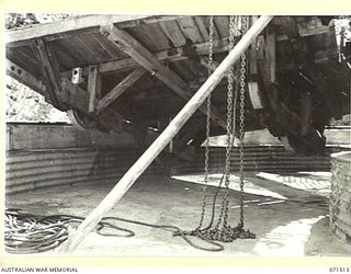 PORT MORESBY, PAPUA, NEW GUINEA. 1944-03-27. THE NO 1 GUN EMPLACEMENT AT BOOTLESS BATTERY COAST ARTILLERY WITH THE LOADING PLATFORM RAISED BY BLOCK AND TACKLE TO SHOW CONSTRUCTION ON THE UNDERSIDE ..