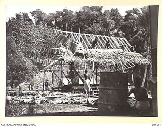 SIPILANGAN, NEW BRITAIN, 1945-07-27. NATIVE REFUGEES BUILDING A HUT FOR THE COMMANDING OFFICERS OFFICE AT AUSTRALIAN NEW GUINEA ADMINISTRATIVE UNIT REFUGEE CAMP IN THE WIDE BAY AREA. AT PRESENT THE ..