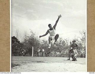 ELA BEACH, NEW GUINEA. 1943-11-13. VX59665 TROOPER A. V. KEEBLE OF THE 2/8TH AUSTRALIAN ARMOURED REGIMENT COMPETING IN THE BROAD JUMP AT THE COMBINED SERVICES SPORTS CARNIVAL