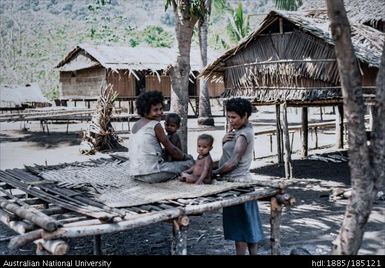 Women relaxing, women and children sitting on platform in village area