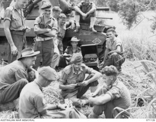 GUSIKA, NEW GUINEA. 1944-03-15. MATILDA TANK CREWS FROM THE 1ST TROOP "A" SQUADRON, AND FROM BATTALION HEADQUARTERS, 1ST TANK BATTALION, RELAX BEFORE A TEST SHOOT. IDENTIFIED PERSONNEL ARE:- ..