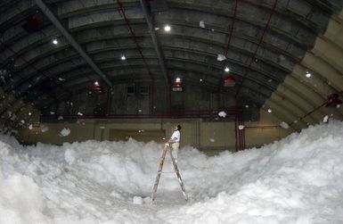 A US Air Force (USAF) Contractor for the Civil Engineering Squadron (CES), 36th Wing, Andersen Air Force Base (AFB), Guam (GU), takes pictures and evaluates a test of the High Expansion (HI-EX) foam system used for fire protection inside aircraft hangars. The Jet Ex foam produced by the Ansul Corporation covers the hangar up to twelve feet high preventing the spread of fire