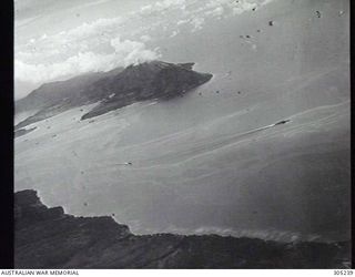 RABAUL, NEW BRITAIN. 1943-11-05. A JAPANESE CRUISER, PROBABLY THE MOGAMI, AND SMALLER SHIPS MANOEUVRING DURING A RAID BY CARRIER-BASED AIRCRAFT OF THE US NAVY. (NAVAL HISTORICAL COLLECTION)