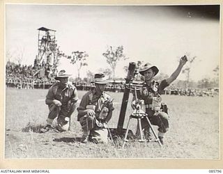 WONDECLA, ATHERTON TABLELAND, QLD. 1945-01-19. THE 2/3 PIONEER BATTALION TEAM APPLYING RANGE CORRECTIONS WHILE COMPETING IN THE 3 INCH MORTAR CONTEST DURING THE 9 DIVISION GYMKHANA AND RACE MEETING ..