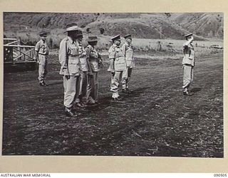 NEAR NADZAB, NEW GUINEA. 1945-03-26. LORD WAKEHURST, GOVERNOR OF NEW SOUTH WALES (1), TAKING THE GENERAL SALUTE DURING HIS REVIEW OF 2 NEW GUINEA INFANTRY BATTALION AT CAMP DIDDY. IDENTIFIED ..