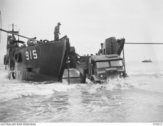 TOKO, BOUGAINVILLE, SOLOMON ISLANDS. 1945-03-20. A 3 TON VEHICLE USED BY THE 11TH FIELD COMPANY, ROYAL AUSTRALIAN ENGINEERS, BEING TOWED ASHORE THROUGH HEAVY SURF FROM THE LCT (LANDING CRAFT TANK) ..