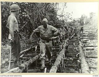 1943-01-14. ROAD BUILDERS FOLLOWING UP THE ADVANCING ALLIED TROOPS, TANKS SLITHERED ALONG THIS PATH IN THE FIGHT AGAINST THE JAPS AND INFANTRY, CARRYING HEAVY EQUIPMENT, OFTEN SANK TO THEIR KNEES ..