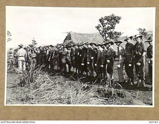DUMPU, RAMU VALLEY, NEW GUINEA. 1944-01-03. PERSONNEL OF THE 2/12TH INFANTRY BATTALION LINE UP FOR A CUP OF TEA AT THE YOUNG MEN'S CHRISTIAN ASSOCIATION HUT ON THEIR ARRIVAL AT DUMPU. IDENTIFIED ..