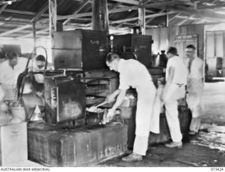 LAE, NEW GUINEA. 1944-05-24. VX36796 PRIVATE C.R. WILSON (1), COOKING THE EVENING MEAL WITH A WILES STEAMER COOKER IN THE KITCHEN OF THE 2/7TH GENERAL HOSPITAL. THE COOKER, AN AUSTRALIAN INVENTION, ..