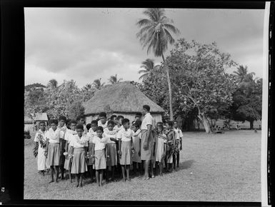 Group of girls and boys with an adult at the meke, Vuda village, Fiji