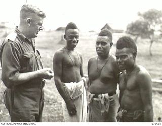 MADANG, NEW GUINEA. 1944-08-29. NX12229 LIEUTENANT-COLONEL H.T. ALLAN, OBE, MC, COMMANDING OFFICER, LMADANG BASE SUB-AREA AND THREE NATIVE BOYS, TIMO, SARU AND MALACHI, WHO ESCAPED FROM JAPANESE ..