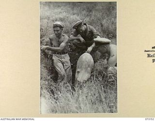 ALEXISHAFEN, NEW GUINEA. 1944-05-11. MEMBERS OF A RMSU (RENDERING MINES SAFE UNIT) RAN EXAMINING A 500 POUND UNEXPLODED BOMB. THE BOMB WAS DISCOVERED DURING THEIR SEARCH AT ALEXISHAFEN NO. 1 ..