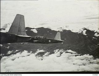 NEAR THE FINISTERRE RANGE, NEW GUINEA. 1944-02-27. IN FLIGHT VULTEE VENGEANCE DIVE BOMBER AIRCRAFT OF NO. 24 SQUADRON RAAF FLY PAST THE FINISTERRE RANGE EN ROUTE TO AN AIR ATTACK ON THE ..