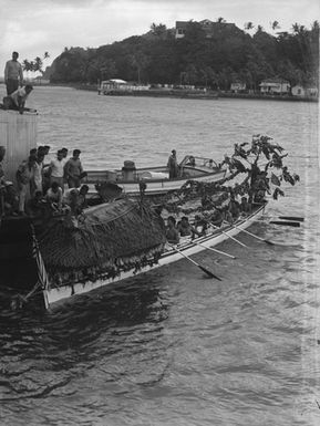 [View of Pacific island people rowing a boat]