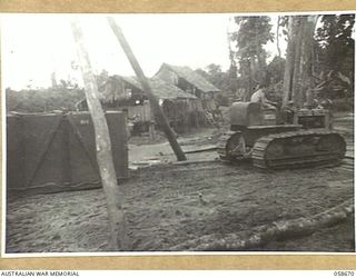 BULLDOG, NEW GUINEA, 1943-09-16. HAULING A 2 TON CRATE OF MACHINERY BENEATH A SET OF SHEAR LEGS IN ORDER TO LOAD IT ON TO A TRUCK FOR TRANSPORT TO WAU