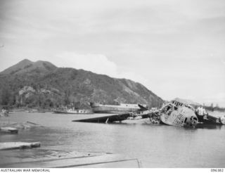 RABAUL, NEW BRITAIN, 1945-09-10. WRECKED JAPANESE 4 ENGINE TRANSPORT AIRCRAFT IN SIMPSONS HARBOUR. ONE OF THE SCENES AT RABAUL FOLLOWING THE SURRENDER OF THE JAPANESE. TROOPS OF 4 INFANTRY BRIGADE ..