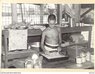 BOUGAINVILLE. 1945-09-28. JAPANESE SOLDIER PREPARING FOOD FOR SICK AND WOUNDED PATIENTS WHO ARE BEING CARED FOR BY JAPANESE MEDICAL OFFICIALS UNDER 7 FIELD AMBULANCE SUPERVISION