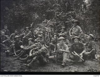 MOMOTE, LOS NEGROS ISLAND, ADMIRALTY ISLANDS. 1944-03-08. GROUND STAFF OF A RAAF KITTYHAWK SQUADRON TAKE A FEW MINUTES OFF FOR A SMOKE IN THEIR CAMP AREA. SOME ARE WEARING CAMOUFLAGE PATTERN ..