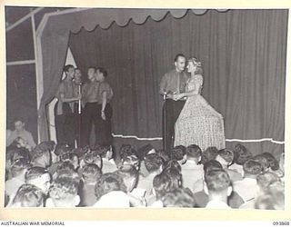 LAE AREA, NEW GUINEA, 1945-07-09. CORPORAL B. DU VE IN A SCENE FROM "A PRETTY GIRL" DURING THE REVUE "OVER TO YOU". IT WAS STAGED BY 19 LINES OF COMMUNICATION AREA SIGNALS IN THE UNIT'S RECREATION ..