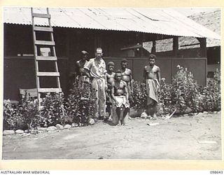 NADZAB, NEW GUINEA. 1945-10-30. SERGEANT S.R. MARSHALL, AUSTRALIAN NEW GUINEA ADMINISTRATIVE UNIT, OUTSIDE HIS HOUSE AT THE EROP COMPOUND WHERE AN EXPEDITION OF 1 MOBILE VETERINARY SURVEY UNIT MADE ..