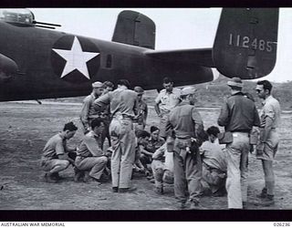 NEW GUINEA, 1942-08-10. AMERICAN AND AUSTRALIAN BOMBING CREWS RECEIVING LAST MINUTE INSTRUCTIONS FROM THE FLIGHT COMMANDER WHO IS OBSCURED FROM VIEW, IN THE CENTRE OF THE GROUP