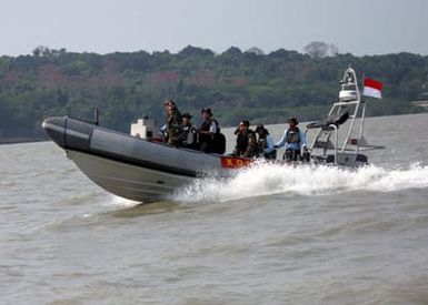 US Navy (USN) Boatswain's Mate First Class (BM1) Christopher White (left), Mobile Security Squadron Seven (MSS-7), Detachment 72, Guam, signals to another rigid hull inflatable boat (RHIB) during a small boat tactics demonstration with the Indonesian Navy's Kopaska Pasukan Katak (Frogman Force) in support of the Indonesian phase of Exercise COOPERATION AFLOAT READINESS AND TRAINING (CARAT). CARAT is a regularly scheduled series of bilateral military training exercises with several Southeast Asia nations designed to enhance interoperability of the respective sea services