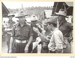 MUSCHU ISLAND, NEW GUINEA. 1945-10-10. MAJOR E.S. OWENS, ASSISTANT ADJUTANT AND QUARTERMASTER GENERAL, HEADQUARTERS 6 DIVISION WITH JAPANESE MEDICAL OFFICERS DISCUSSING THE HYGIENE ADMINISTRATION ..