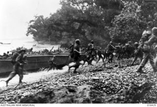 NEW GUINEA. 10 JANUARY 1944. US TROOPS RUSH THE BEACH FROM LANDING CRAFT AS THEY ARRIVE AT SAIDOR TO OUTFLANK THE ENEMY WHO IS NOW TRAPPED ON THE HUON PENINSULA