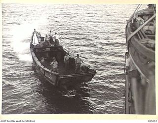 AT SEA, OFF BUIN, BOUGAINVILLE. 1945-08-20. A JAPANESE BARGE CARRYING A FLAG OF TRUCE BEARING IN TOWARDS THE CORVETTE HMAS LITHGOW. THE BARGE IS CARRYING AN ENVOY FROM LIEUTENANT GENERAL M. KANDA, ..