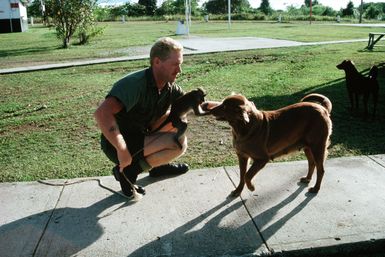 Construction Mechanic 2nd Class Timmy W. Albrecht plays with pets from his base camp at Palau. Albrecht is a United States (US) Navy construction battalion member assigned to Civic Action Team deployed to the area to aid villagers with construction projects and offer vocational training