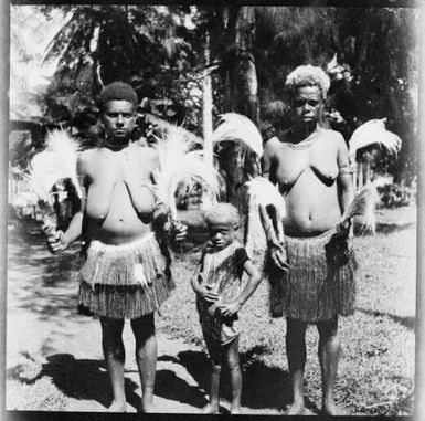 Two women wearing grass skirts with a child, New Guinea, ca. 1936 / Sarah Chinnery