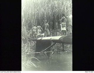 NEW GUINEA, 1942-1943. POSSIBLY WAIROPE RIVER - PROBABLY A NAVY COASTWATCHER FLOWN IN BY CATALINA PREPARING TO GO TO HIS POST AIDED BY MEMBERS OF THE COASTWATCHING PARTY. (5 OF 5)