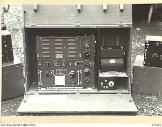 FINSCHHAFEN, NEW GUINEA. 1944-03-27. THE 188F, (UNITED STATES ARMY 191F), WIRELESS TRTANSMITTER-RECEIVER AT "B" AUSTRALIAN CORPS SIGNALS. THE TRANSMITTER IS TO THE RIGHT WITH THE POWER UNIT IN THE ..