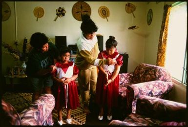 Two girls getting dressed for ear-piercing ceremony, Lakepa, Niue