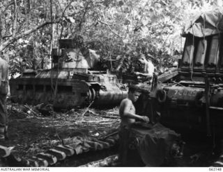 SCARLET BEACH AREA, NEW GUINEA. 1943-12-21. SX28156 CRAFTSMAN A. M. CROXTON (FOREGROUND) AND SX23601 CRAFTSMAN H. T. WILKINS (SITTING ON TANK) OF THE 1ST AUSTRALIAN TANK BATTALION GROUP WORKSHOP, ..