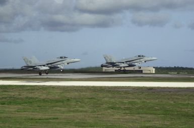 Two US Marine Corps (USMC) F/A-18C Hornets aircraft assigned to Marine Fighter Attack Squadron One Two Two (VMFA-122), take off from the flight line at Anderson Air Force Guam, during exercise Jungle Shield