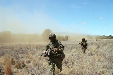 Members of Company C, 1ST Battalion, 35th Infantry, 25th Infantry Division, fan out after being dropped at a landing zone by helicopters from the 25th Comabt Aviation Battalion. They are conducting an airmobile assault against Australian Army units acting as opposing forces for US troops undergoing their annual Army Training and Evaluation Program (ARTEP) at the Pohakuloa Training Area