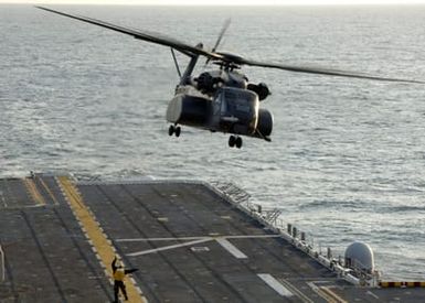 A US Navy (USN) MH-53E Sea Stallion helicopter assigned to Helicopter Mine Countermeasure Squadron One Four (HM-14) is directed to depart the flight deck on the Amphibious Assault Ship USS SAIPAN (LHA 2)