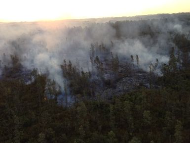 View of Kilauea Volcano Puu Oo lava flow in Pahoa on the Big Island of Hawaii. Lava flows through wooded, forest area. Photo taken by FEMA during helicopter flyover of the Big Island on Monday, November 10, 2014.