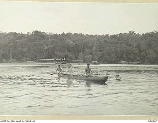 JACQUINOT BAY, NEW BRITAIN. 1944-11-14. VX27 MAJOR-GENERAL A.H. RAMSAY, CBE, DSO, ED, GENERAL OFFICER COMMANDING, 5TH DIVISION, BEING FERRIED ASHORE BY NATIVES IN THEIR LAKATOI ON HIS ARRIVAL IN ..