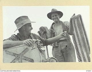 MADANG, NEW GUINEA, 1944-04-30. MEMBERS OF THE ROYAL AUSTRALIAN ENGINEERS DISPLAY BELTS OF JAPANESE .5 INCH MACHINE GUN AMMUNITION FOUND ON MADANG AIRFIELD. THE AMMUNITION FED THE GUNS OF JAPANESE ..