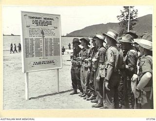 SALAMAUA, NEW GUINEA. 1944-04-30. MEMBERS OF THE 4TH FIELD REGIMENT AND THE 15TH INFANTRY BATTALION READING THE LIST OF NAMES ON THE TEMPORARY MEMORIAL AT THE SALAMAUA WAR CEMETERY. THE OFFICIAL ..