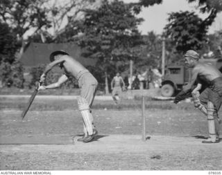 MADANG, NEW GUINEA. 1944-09-17. NX125239 CORPORAL F.C. COLWELL (1) MEMBER OF THE 165TH GENERAL TRANSPORT COMPANY CRICKET TEAM PLAYS A STROKE DURING THE MATCH AGAINST A TEAM FROM THE 2/4TH FIELD ..