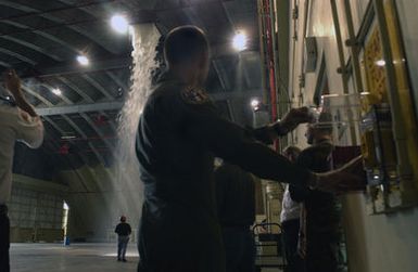 US Air Force (USAF) Colonel (COL) P.K. White, Commander of the 36th Wing, Andersen Air Force Base (AFB), pulls an emergency lever to test a High Expansion (HI-EX) foam system used for fire protection inside aircraft hangars