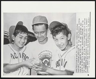 Winners - Nobuo Yamauchi, center, manager of the Hilo, Hawaii Little League team, poses with two of his players who aided in Hilo’s win over Montreal, Canada 8-5 in the second game of the Little League World Series at Williamsport. Russell Arikawa,left,hit a bases-loaded home run while Gary Matsumoto was the winn