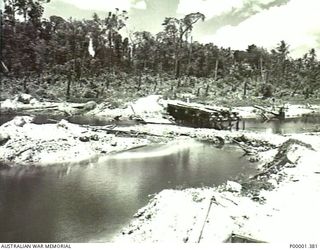 NEW IRELAND, 1945-10. LOW LEVEL RIVER CROSSING BESIDE A PARTLY CONSTRUCTED BRIDGE. (RNZAF OFFICIAL PHOTOGRAPH.)