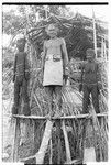 Folofo'u, wearing old police belt, on speaking platform with fernwood 'ea figures made by Arimae of Furi'ilae for the opening of the Kwaio Cultural Centre in August 1979