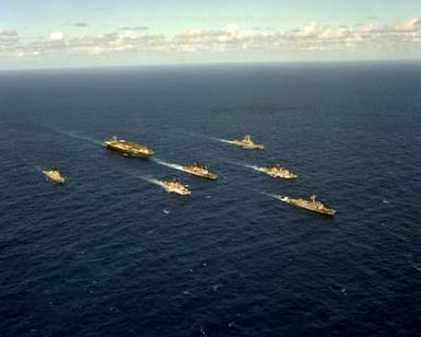 A starboard bow view of the nuclear-powered aircraft carrier USS CARL VINSON (CVN-70) underway near Hawaii with its battle group. Left to right: the guided missile cruiser USS WORDEN (CG-18), the frigate USS COOK (FF-1083), the destroyer USS HEWITT (DD-966), the nuclear-powered guided missile cruiser USS TEXAS (CGN-39), the frigate USS BARBEY (FF-1088) and the guided missile frigate USS SIDES (FFG-14)