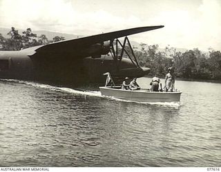 MALMAL VILLAGE, JACQUINOT BAY, NEW BRITAIN. 1944-12-21. NX35000 LIEUTENANT-GENERAL V.A.H. STURDEE, CB, CBE, DSO, GOC, 1ST AUSTRALIAN ARMY LEAVING THE MARTIN "MARINER" FLYING BOAT TO GO ABOARD THE ..